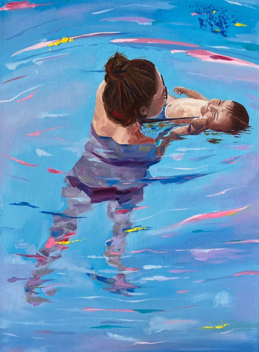 A mother holding her daughter in the blue water of a swimming pool.
